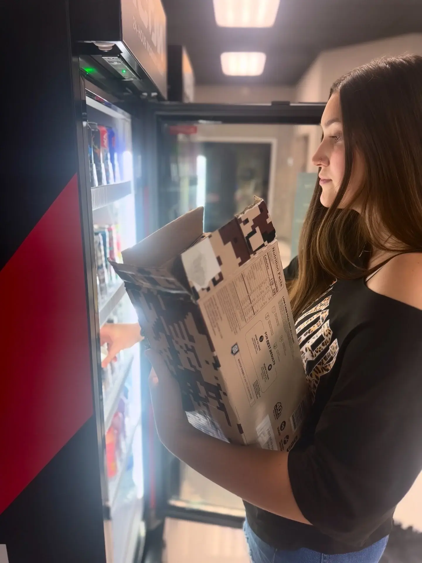 Woman choosing a drink from an open AI smart cooler